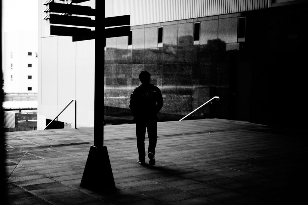A person walking alone along a sunlit path, suggesting choice and reflection.